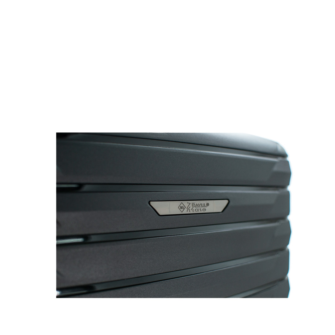 Detailed view of a sleek luggage design featuring a metallic logo and textured surface.